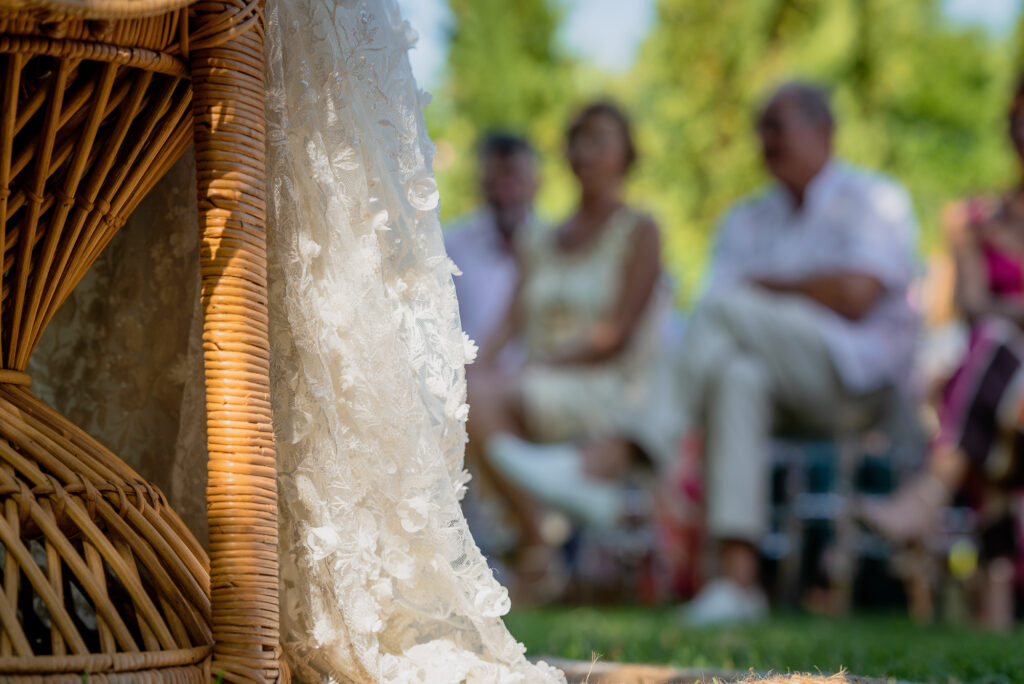 Photographe mariage Périgueux – robe de mariée lors de la cérémonie avec invités en arrière-plan